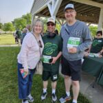 A middle-aged white couple with their young adult son, who has visible signs of a disability.