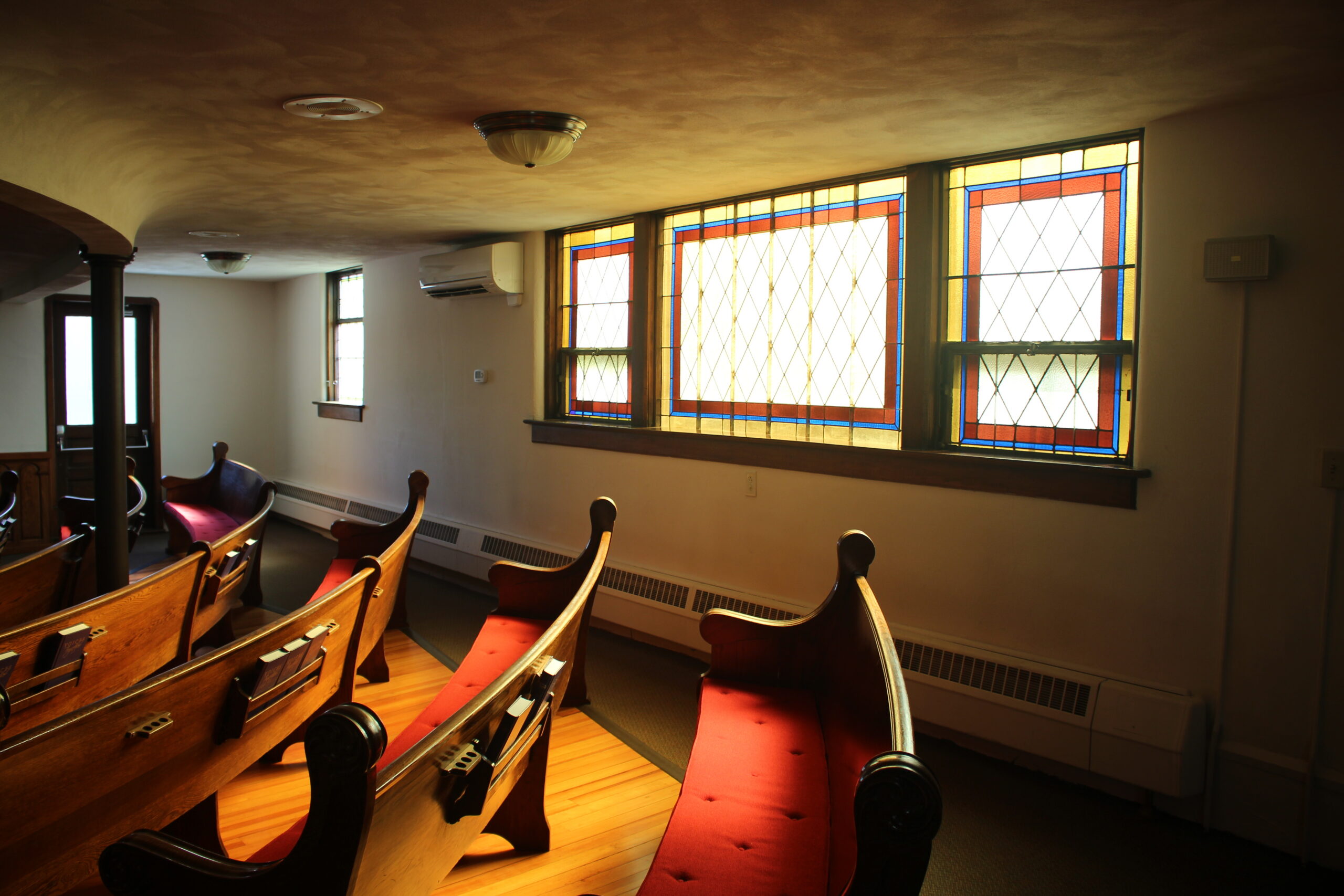 Church pews in the light of stained glass windows