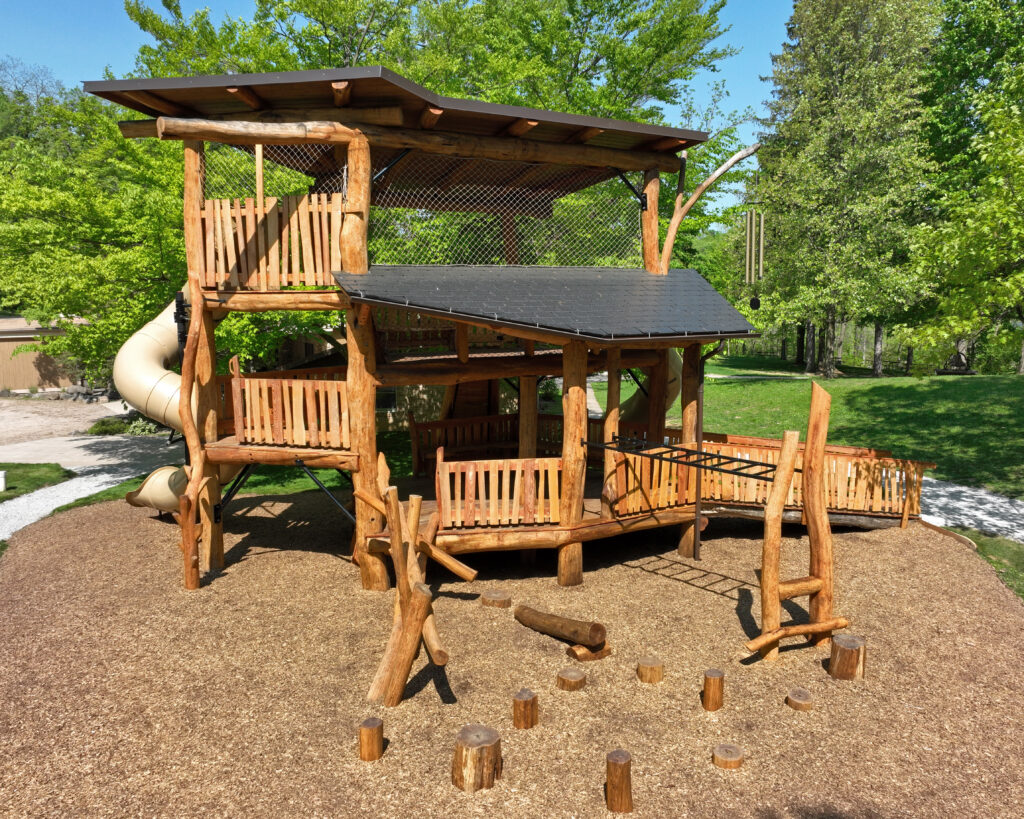 three level play structure surrounded by trees