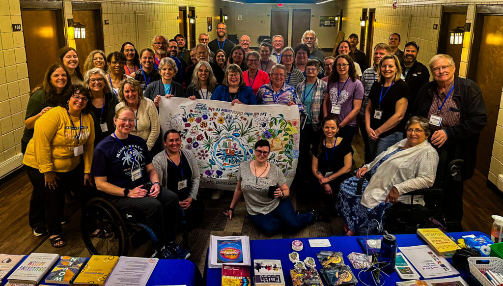 a group photo of all the All In participants holding a painted banner