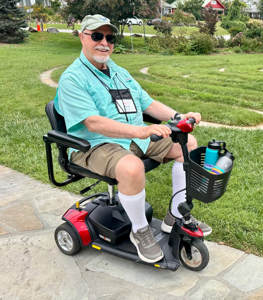 man with green shirt and brown shorts riding on a red scooter