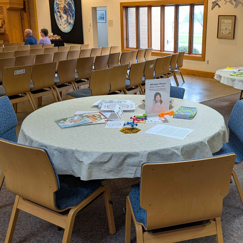 a table with coloring pages and fidget toys at the back of the sanctuary