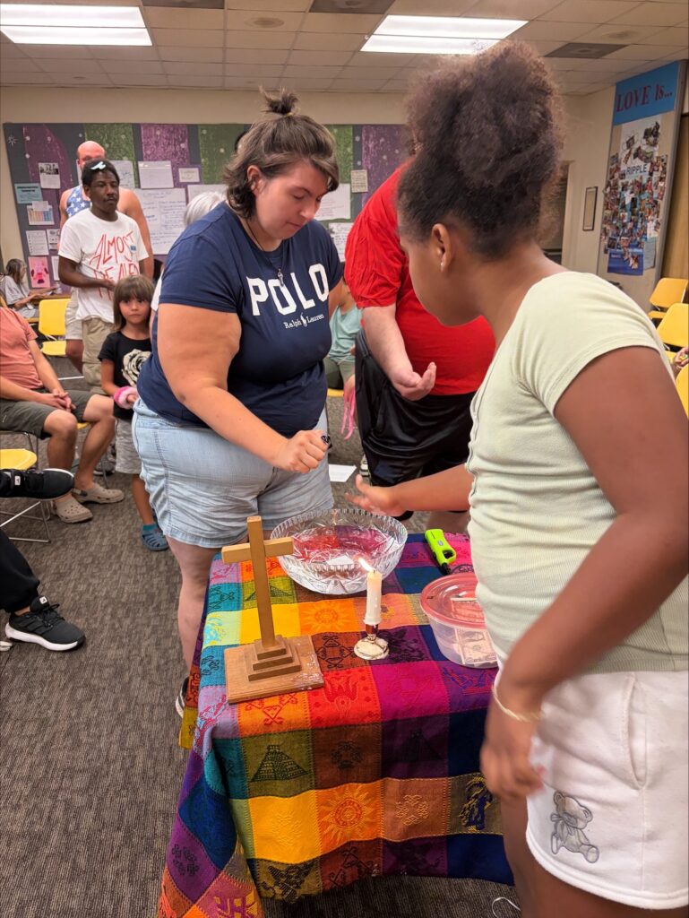 two women add salt to a bowl of water during worship