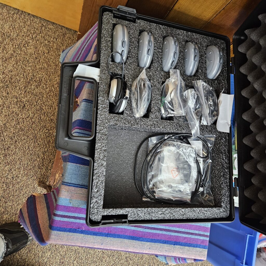 an open case with hearing assistance devices lined up vertically inside